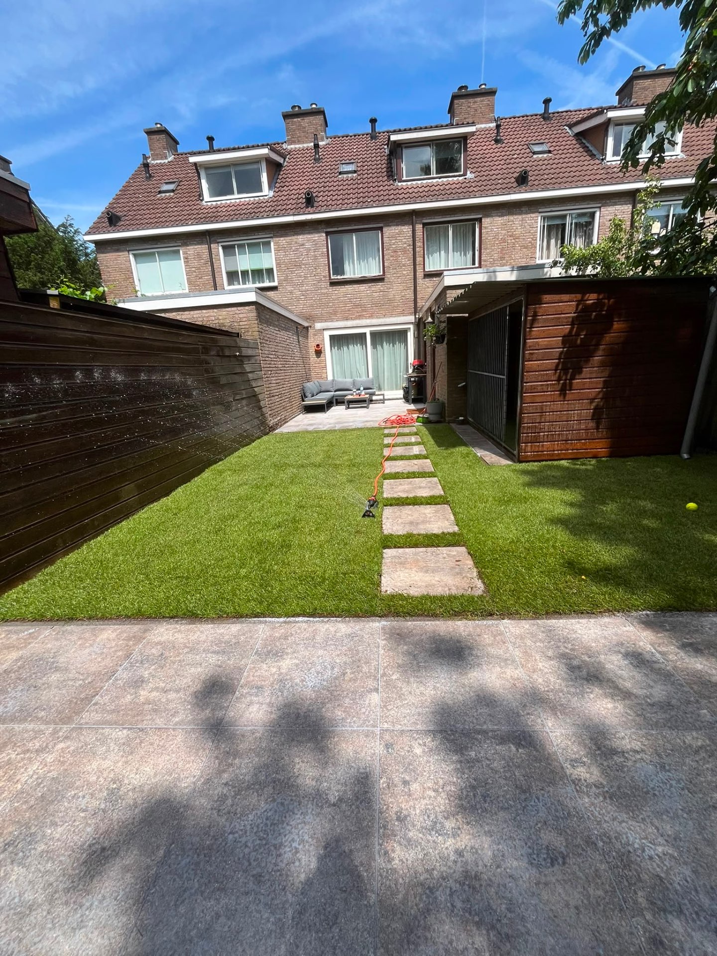 Achtertuin met kunstgras & stapstenen pad