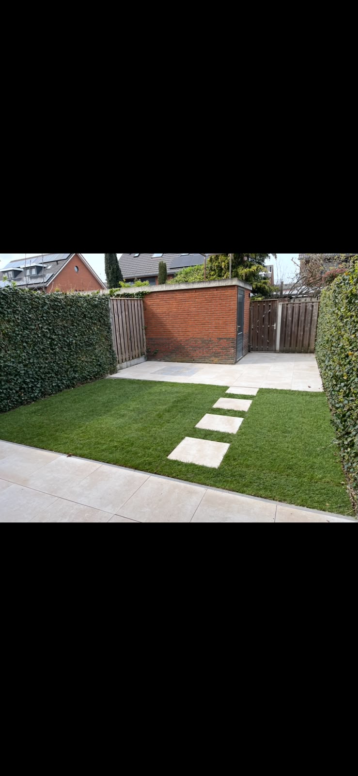 Strakke achtertuin met stapstenen door het gras